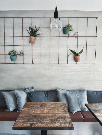 Monica Mariz bistrot trento alta paretre griglia con piante e panca