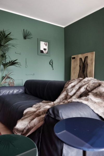 Monica Mariz le albere buxter muri colore verde e divano in pelle blu